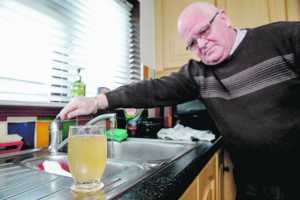 Michael Mulcahy with a sample of the water from his tap in Kennedy Park. Picture: Keith Wiseman