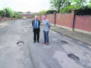 Willie O'Dea inspecting the road surface with local Fianna Fail representative Christy McInerney.
