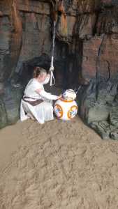 Ania Kowalska dressed as Rey from Star Wars with BB-8.