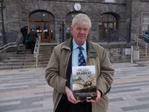 Joe Coleman outside Colbert Station with his book, Falling Gradient