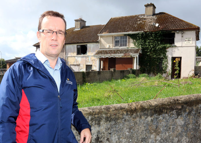 Cllr Joe Leddin outside derelict houses on Lenihan Avenue. Photo: Brendan Gleeson