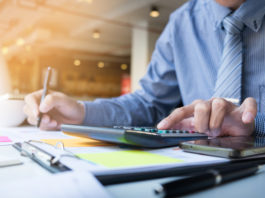 Business finance man calculating budget numbers, Invoices and financial adviser working. Limerick Post News