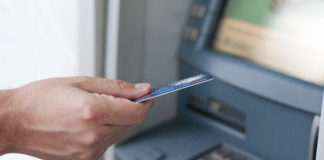 Hand inserting ATM card into bank machine to withdraw money. businessman men hand puts credit card into ATM