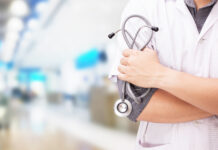 Doctor with a stethoscope in the hands and hospital background