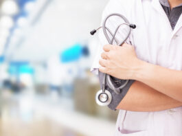 Doctor with a stethoscope in the hands and hospital background