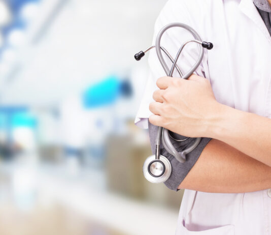 Doctor with a stethoscope in the hands and hospital background