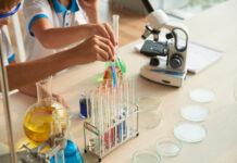 Close-up image of children filling test-tubes with different reagents