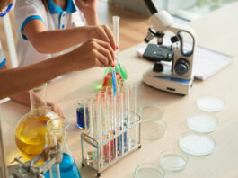 Close-up image of children filling test-tubes with different reagents