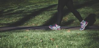 shallow focus photography of person walking on road between grass