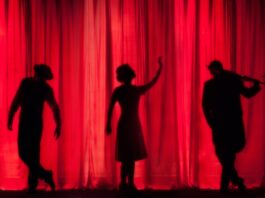 silhouette of three performers on stage