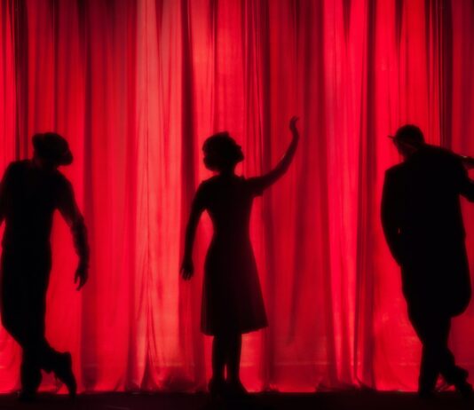silhouette of three performers on stage