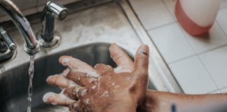 person in white shirt washing hands