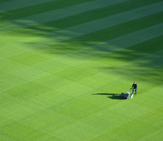 aerial photography of person trimming sports field during day