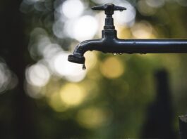 tilt shift lens photography of black steel faucet