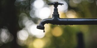 tilt shift lens photography of black steel faucet