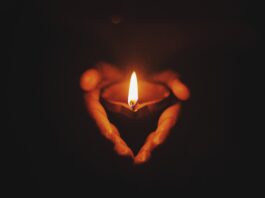 person holding lighted oil lamp