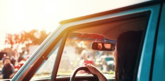 woman holding steering wheel sitting inside car