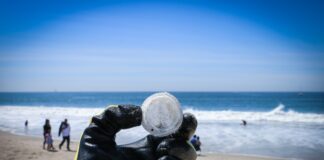 person holding round white ball near body of water during daytime