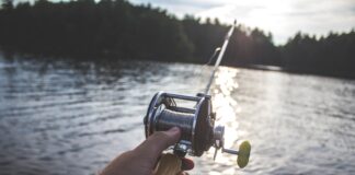 person holding black and silver fishing reel