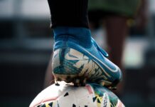 white and blue soccer ball on green grass field