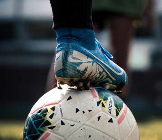 white and blue soccer ball on green grass field