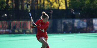 woman playing hockey on fields during daytime