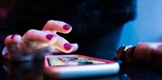 person using black smartphone with gray and pink case