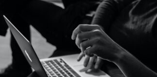 grayscale photo of person using MacBook