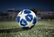 white and blue soccer ball on green grass field