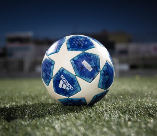 white and blue soccer ball on green grass field
