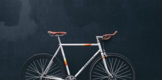 gray fixie bike leaning on black wall