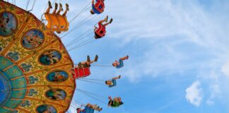 people riding carnival ride under blue skies