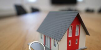 white and red wooden house miniature on brown table