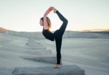 shallow focus photo of woman in black sleeveless shirt doing yoga