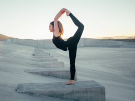 shallow focus photo of woman in black sleeveless shirt doing yoga