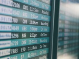 Airport departures timetable showing Delta and Alaska Airlines flights on time and boarding