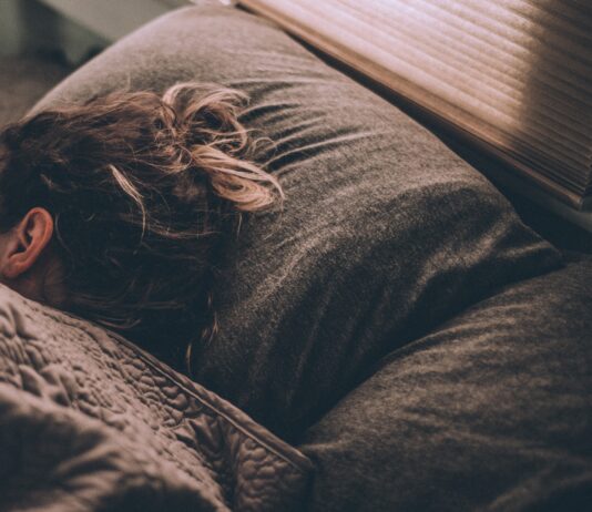 woman sleeping on bed under blankets