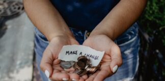 person showing both hands with make a change note and coins