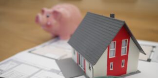 white and red wooden house beside grey framed magnifying glass