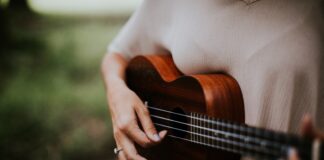 woman playing ukulele at daytime