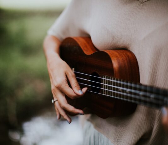 woman playing ukulele at daytime