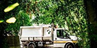 white and green truck on dirt road during daytime