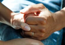 person wearing gold wedding band