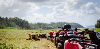 focus photography of ATV's falling in line on grass field