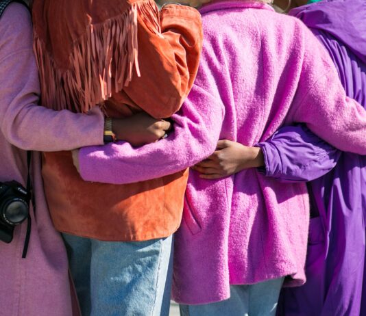 four person holding each others waist at daytime